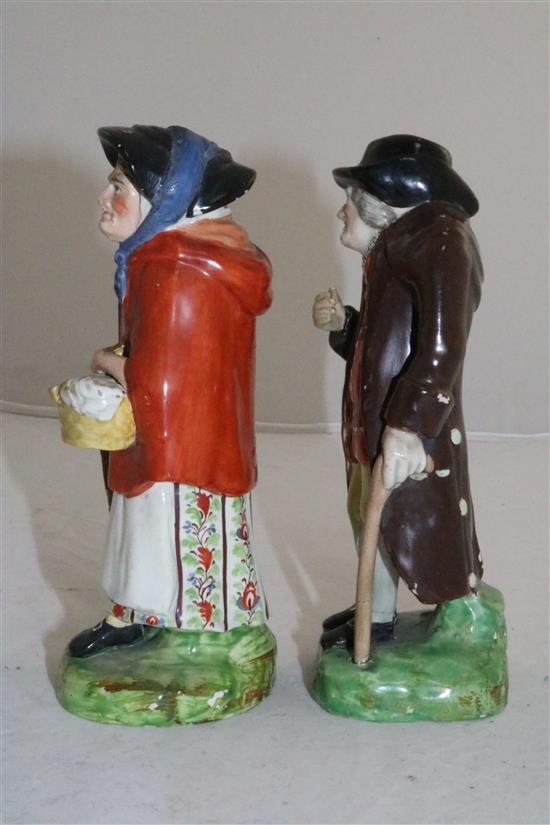 A pair of Staffordshire pearlware figures of an elderly lady and gentleman, c.1830, height 18cm (7.1in.), restorations